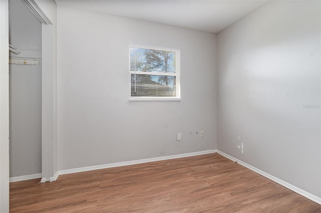 unfurnished room with light wood-type flooring and baseboards