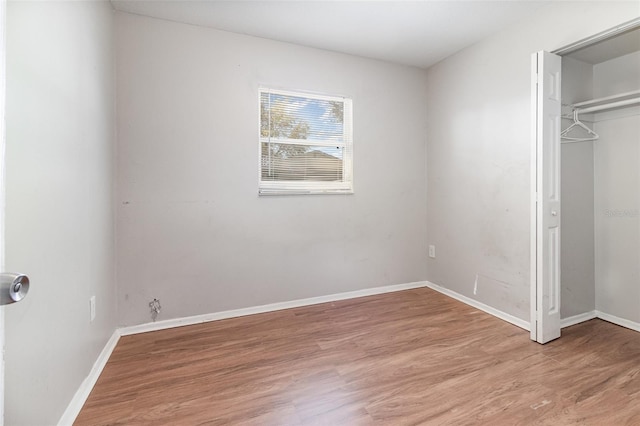 unfurnished bedroom featuring a closet, baseboards, and light wood-style floors