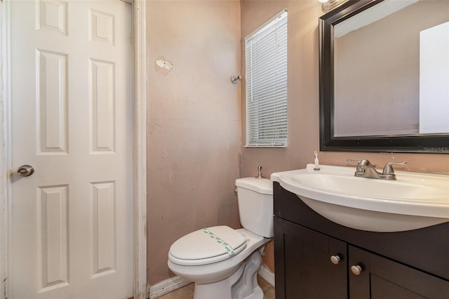 half bathroom with vanity and toilet