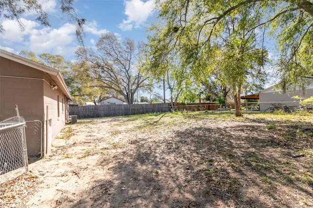 view of yard with central AC unit and fence