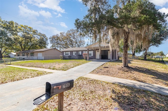 single story home with concrete driveway and fence