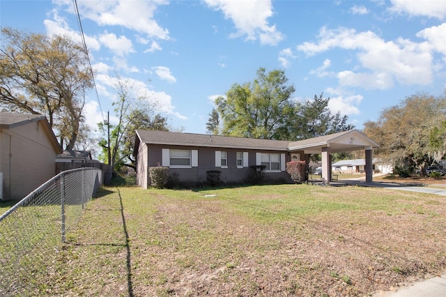 view of front of property featuring brick siding, a carport, a front lawn, and fence