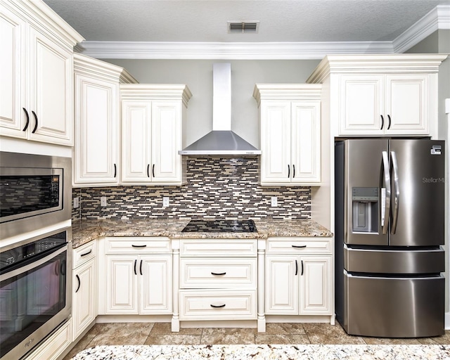 kitchen featuring visible vents, backsplash, light stone counters, stainless steel appliances, and wall chimney exhaust hood