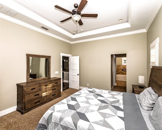 carpeted bedroom with a tray ceiling, visible vents, baseboards, and ornamental molding