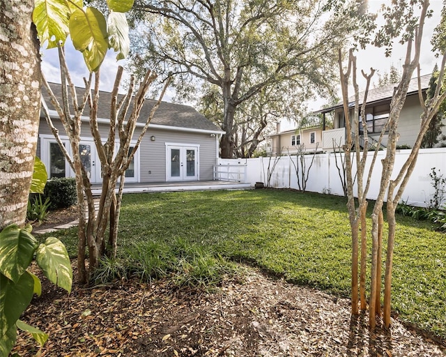 view of yard featuring french doors and fence