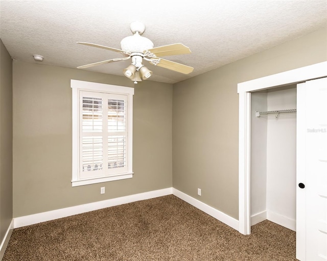 unfurnished bedroom with a closet, baseboards, a textured ceiling, and dark carpet