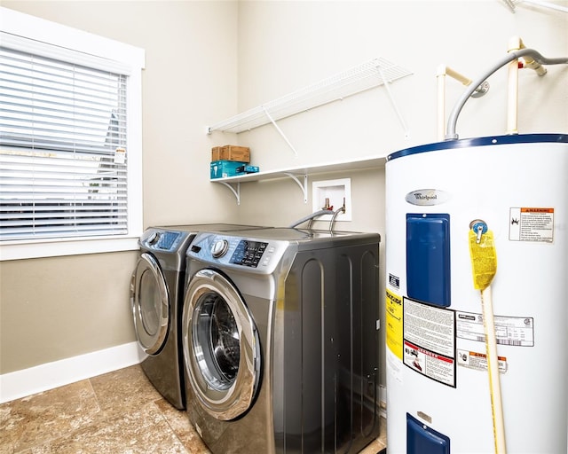 laundry room featuring laundry area, baseboards, independent washer and dryer, and electric water heater