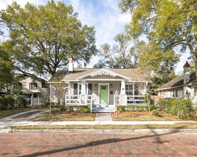 view of front of property featuring covered porch and a chimney