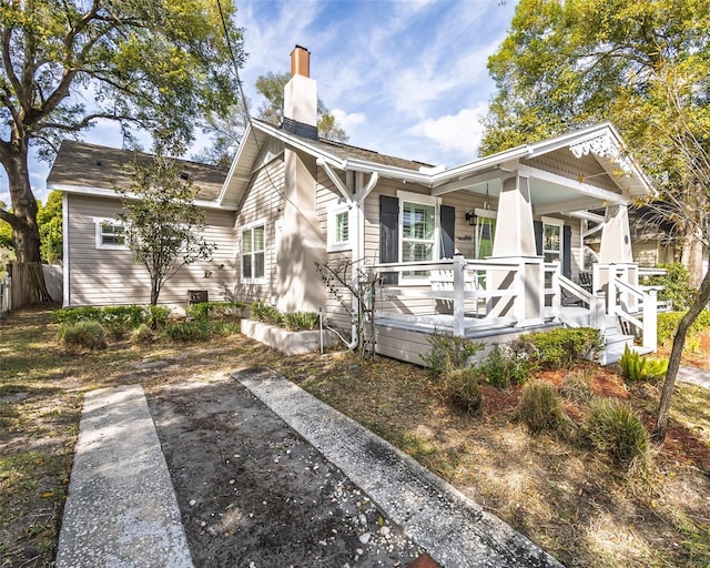 back of property with a porch and a chimney