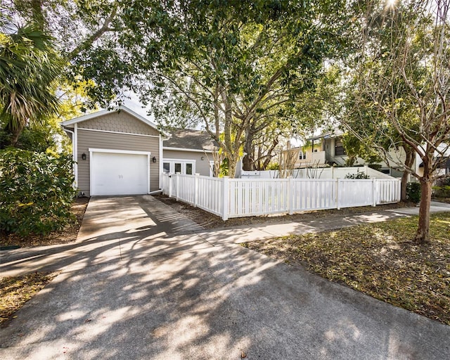 view of front of house featuring a garage, driveway, and a fenced front yard