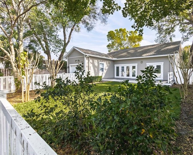 single story home featuring fence, french doors, and a garage