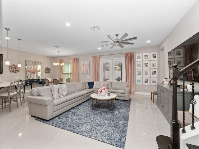 living area featuring recessed lighting, visible vents, ceiling fan with notable chandelier, and stairway