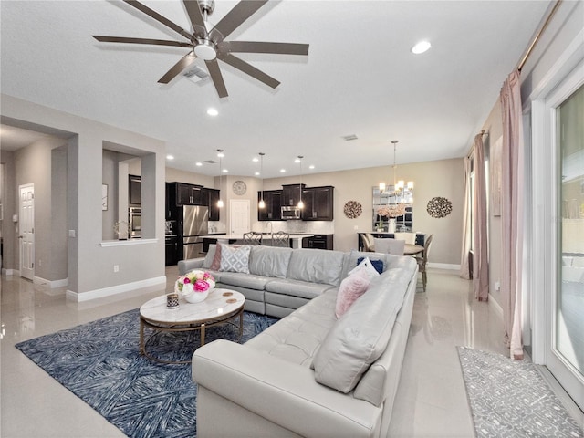 living area with recessed lighting, ceiling fan with notable chandelier, visible vents, and baseboards