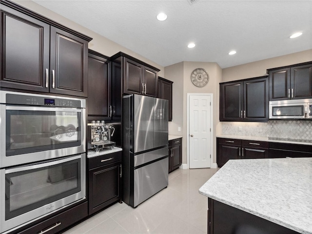 kitchen with tasteful backsplash, recessed lighting, stainless steel appliances, light tile patterned floors, and baseboards