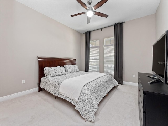 bedroom featuring baseboards, light colored carpet, and ceiling fan