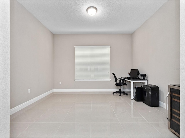 office space featuring tile patterned flooring, beverage cooler, and baseboards