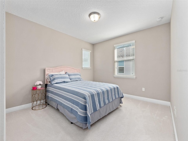 bedroom with carpet flooring, baseboards, and a textured ceiling