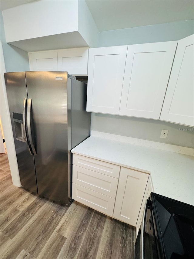 4100 Player Cir Unit 101, Orlando, FL 32808 - kitchen featuring dark wood-style floors, range with electric stovetop, light countertops, and stainless steel refrigerator with ice dispenser