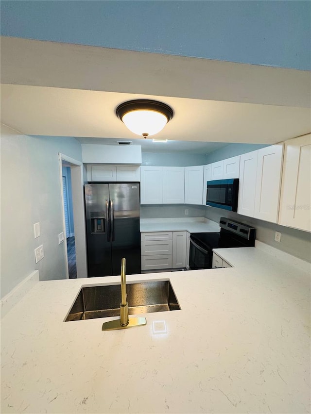 4100 Player Cir Unit 101, Orlando, FL 32808 - kitchen featuring electric range, a sink, light countertops, white cabinetry, and refrigerator with ice dispenser