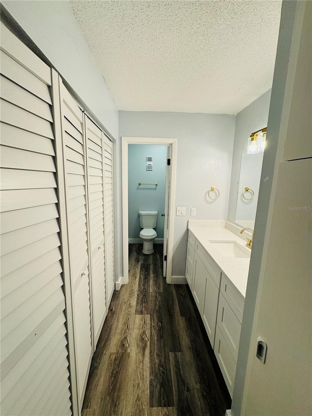 4100 Player Cir Unit 101, Orlando, FL 32808 - bathroom featuring toilet, a textured ceiling, wood finished floors, baseboards, and vanity