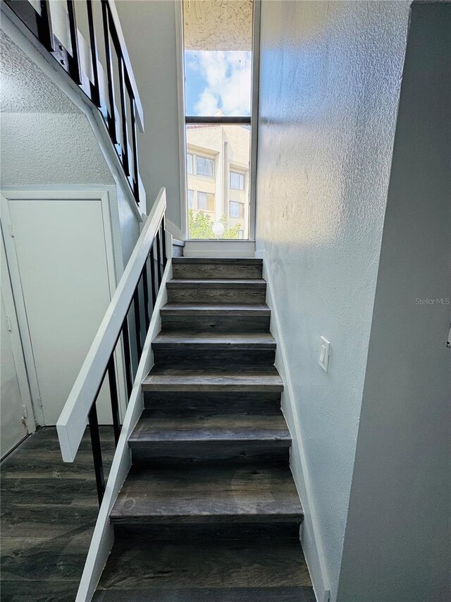 4100 Player Cir Unit 101, Orlando, FL 32808 - staircase featuring baseboards and wood finished floors