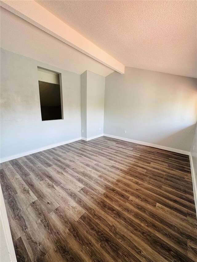 4100 Player Cir Unit 101, Orlando, FL 32808 - spare room with lofted ceiling with beams, baseboards, a textured ceiling, and dark wood-style floors