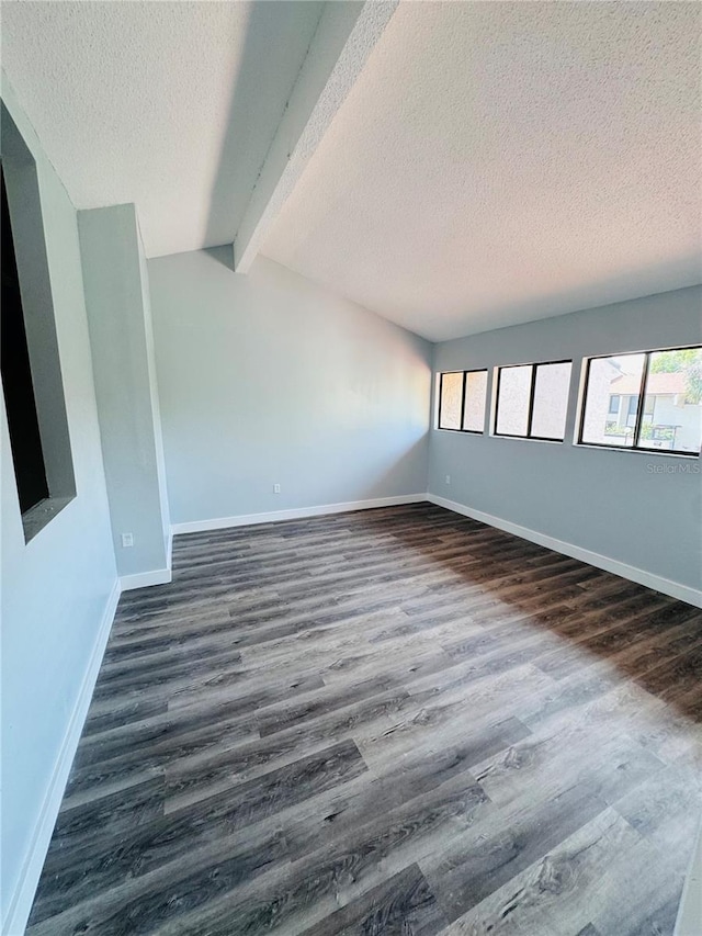 4100 Player Cir Unit 101, Orlando, FL 32808 - spare room with dark wood finished floors, a textured ceiling, lofted ceiling with beams, and baseboards