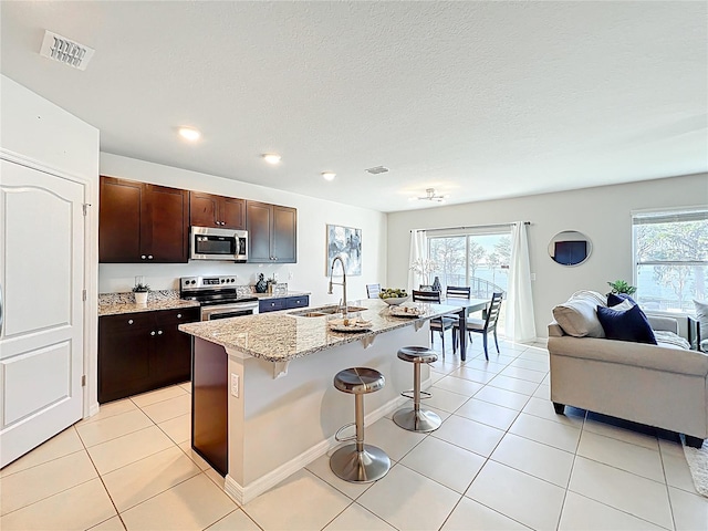 3279 Landing Vw, Tavares, FL 32778 - kitchen with visible vents, appliances with stainless steel finishes, a sink, open floor plan, and a breakfast bar area