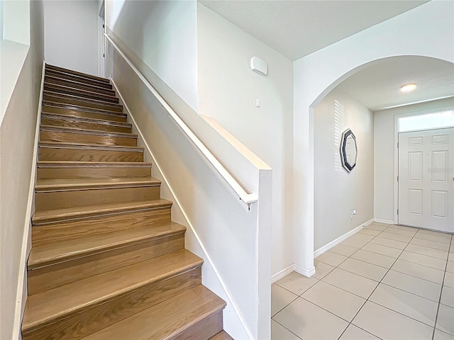 3279 Landing Vw, Tavares, FL 32778 - staircase with arched walkways, baseboards, and tile patterned floors