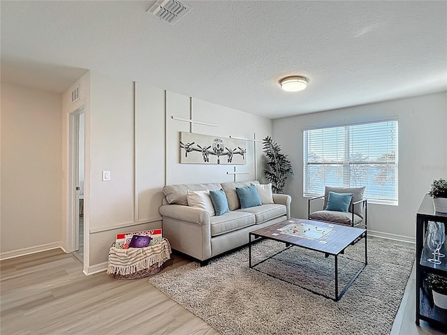 3279 Landing Vw, Tavares, FL 32778 - living room with light wood-type flooring, baseboards, visible vents, and a textured ceiling
