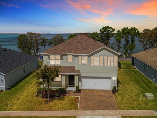 3279 Landing Vw, Tavares, FL 32778 - traditional-style home featuring a garage, a yard, stucco siding, and decorative driveway