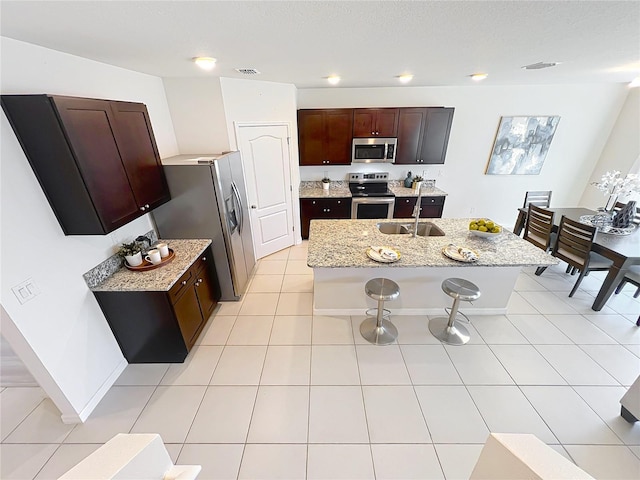3279 Landing Vw, Tavares, FL 32778 - kitchen with an island with sink, a kitchen bar, visible vents, a sink, and stainless steel appliances