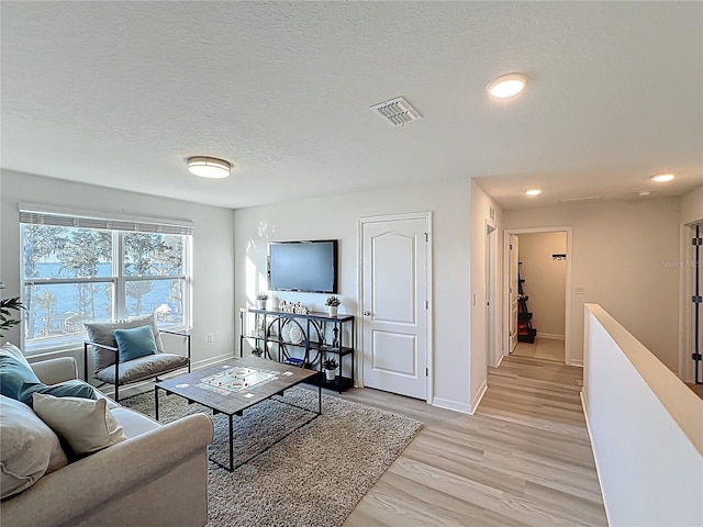 3279 Landing Vw, Tavares, FL 32778 - living room featuring visible vents, baseboards, a textured ceiling, and light wood-style flooring