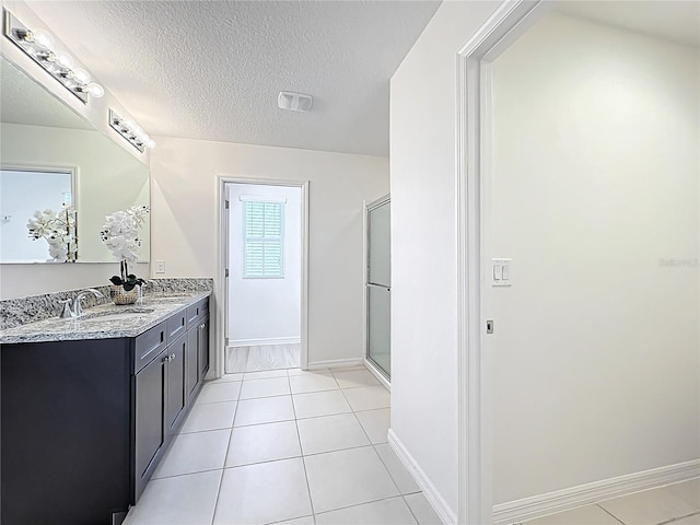 3279 Landing Vw, Tavares, FL 32778 - bathroom with a textured ceiling, a shower with door, a sink, double vanity, and baseboards