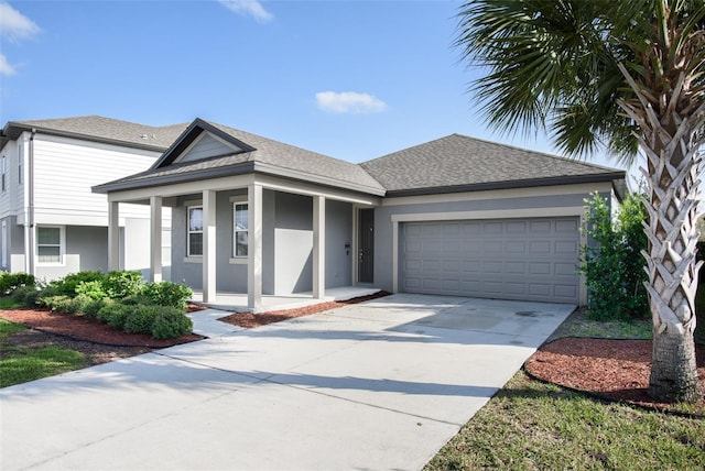 view of front facade featuring a shingled roof, an attached garage, driveway, and stucco siding