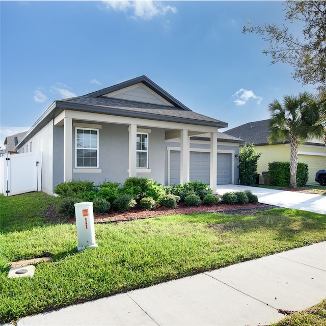 view of front of property with fence, concrete driveway, a front yard, stucco siding, and an attached garage