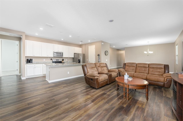 living room featuring dark wood-type flooring, recessed lighting, baseboards, and a chandelier