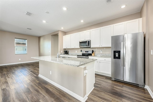 kitchen featuring a sink, stainless steel appliances, dark wood-style floors, white cabinetry, and a kitchen island with sink