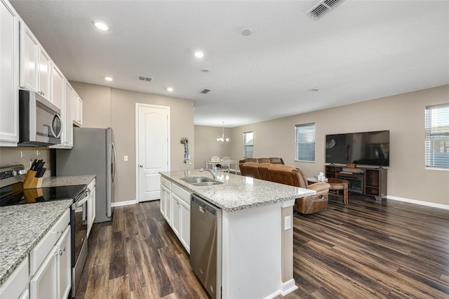 kitchen featuring visible vents, dark wood-style flooring, a sink, appliances with stainless steel finishes, and open floor plan