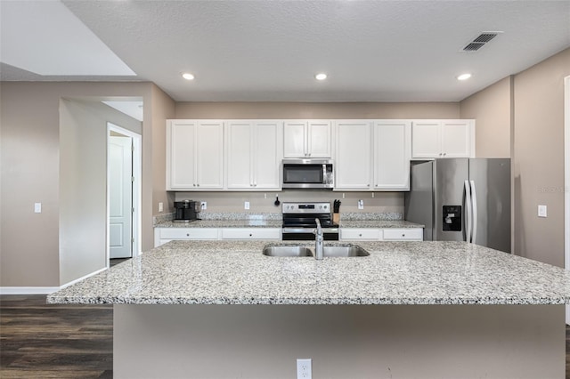 kitchen featuring a center island with sink, white cabinetry, stainless steel appliances, and a sink