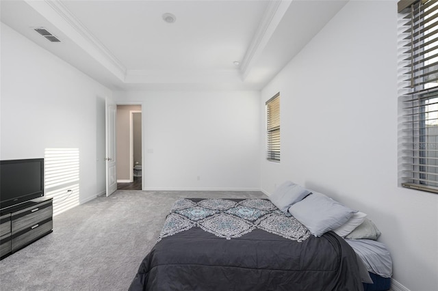 carpeted bedroom with a tray ceiling, crown molding, visible vents, and baseboards