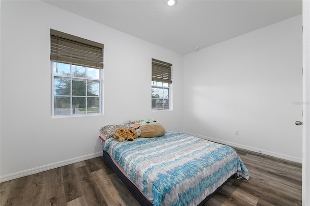 bedroom with baseboards and wood finished floors