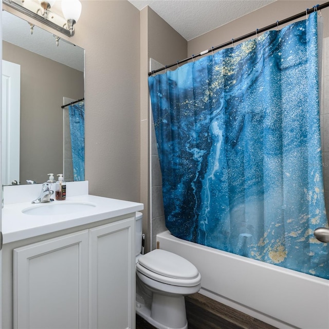 bathroom featuring toilet, vanity, wood finished floors, a textured ceiling, and shower / bathtub combination with curtain