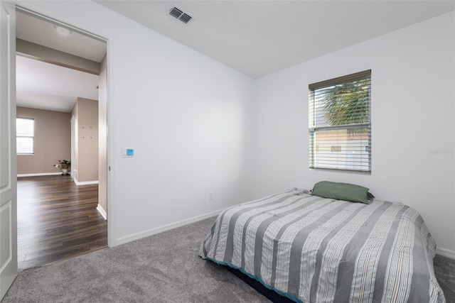 carpeted bedroom featuring visible vents and baseboards