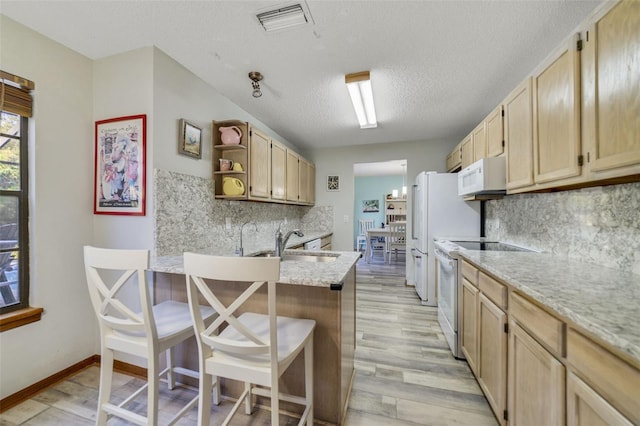 kitchen with white appliances, open shelves, light wood-style flooring, light brown cabinetry, and a sink