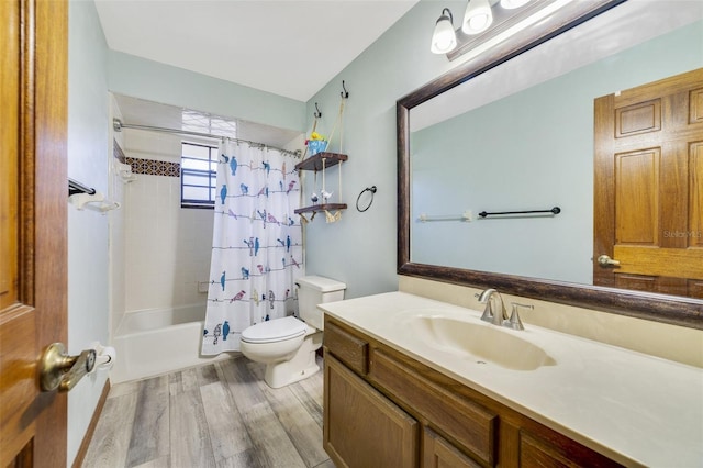 bathroom with vanity, toilet, wood finished floors, and shower / bath combo