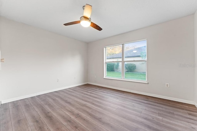 spare room with ceiling fan, baseboards, and wood finished floors