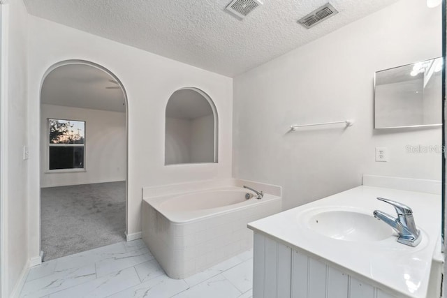 full bathroom with a bath, visible vents, marble finish floor, and a textured ceiling