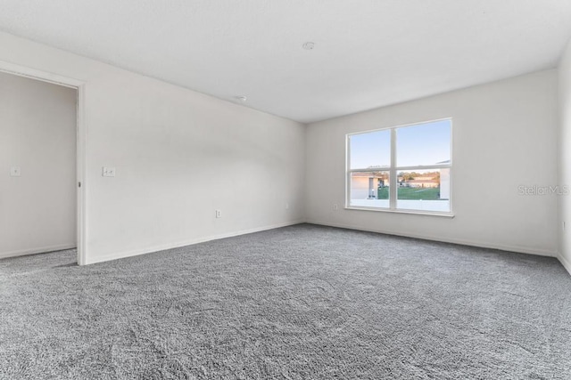 empty room featuring baseboards and carpet floors