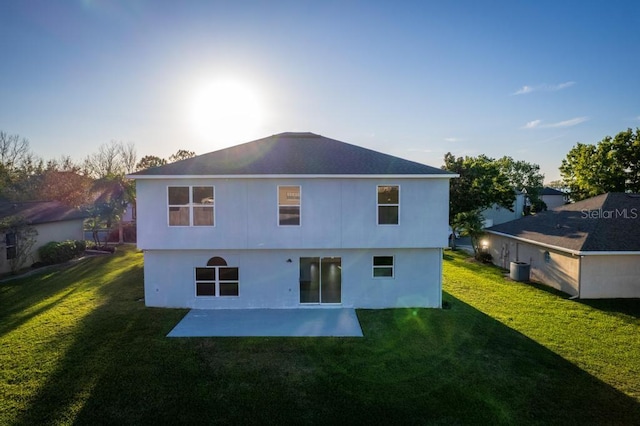 rear view of property featuring a patio, central AC unit, and a lawn